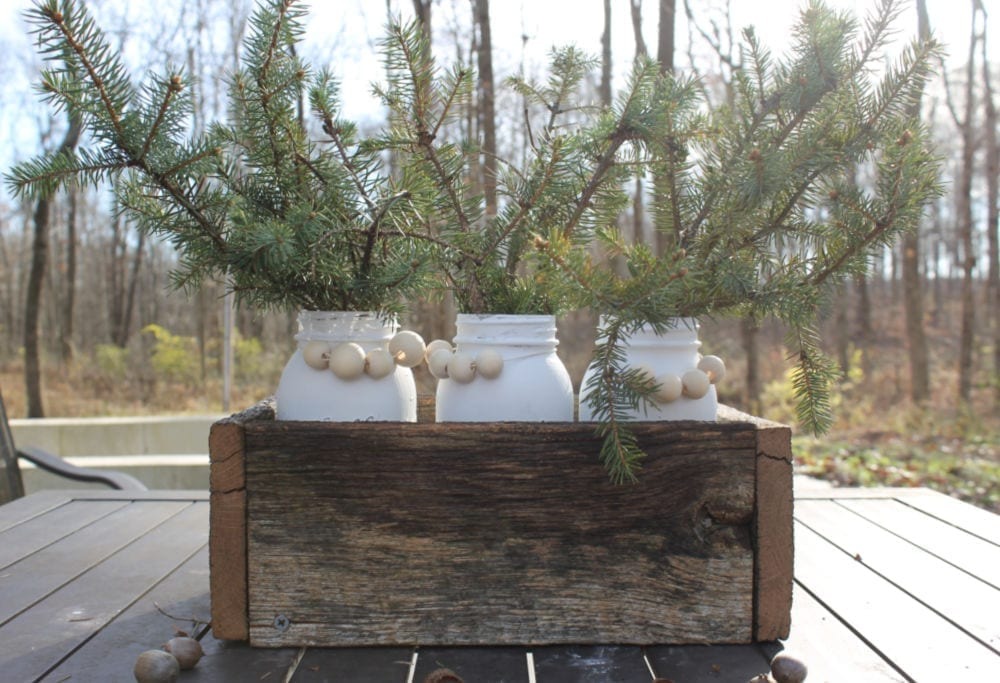 Painted Mason Jars sitting in a wooden box.