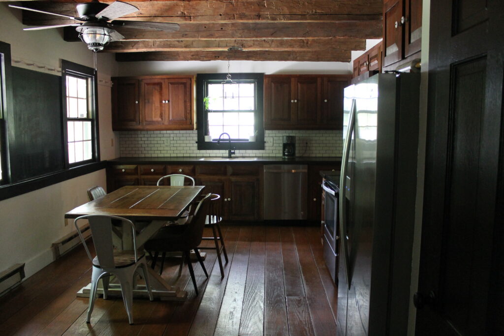 Log cabin kitchen with rough wood ceiling beams